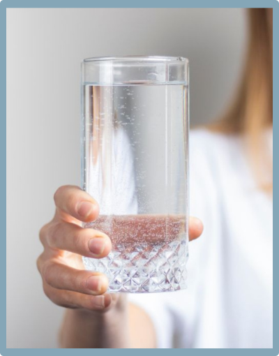 Woman holding glass of pure filtered water