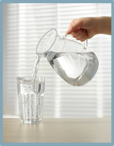 Woman pouring glass of pure filtered water