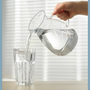 Woman pouring glass of pure filtered water